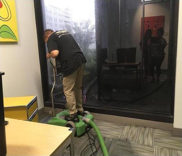worker using equipment to dry out floor 
