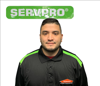 Albanis, SERVPRO employee, in front of white background and SERVPRO sign